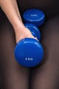 WomanÃ¢â¬â¢s legs with two 4KG dumbbells